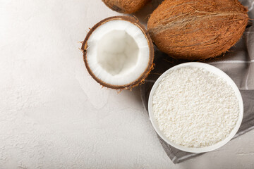 Set of fresh whole and half coconuts and slices on wooden background. Coconut flakes. Vegan. Tropical nut, fruit. Place for text. Copy space.