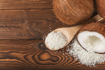 Set of fresh whole and half coconuts and slices on wooden background. Coconut flakes. Vegan. Tropical nut, fruit. Place for text. Copy space.