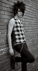 A black and white portrait of an emo style boy with a distinctive haircut with long bangs swept to one side
