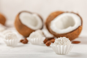 Coconut candies on a wooden background. Candies with chocolate, almonds and delicate butter cream. Coconut flakes. tasty sweets.Tasty ball-shaped chocolate candies.Dessert. Space for text.copy space