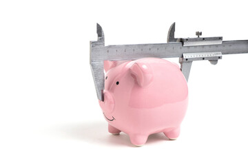 Measuring piggy bank volume with caliper on white background. Concept of finance.
