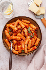 Rigatoni pasta with meat sauce and parmesan cheese on a light table, top view, homemade, no people,