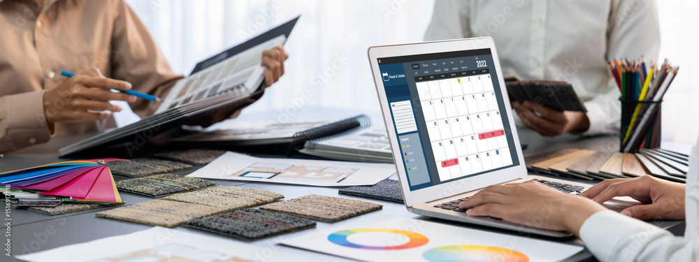 Poster group of interior architect designer team at table choosing color samples with architecture software