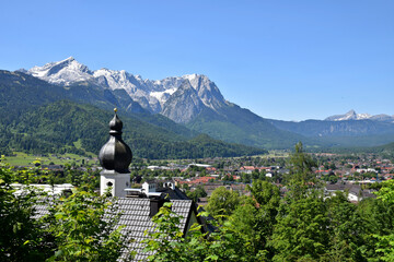 A stunning view of the Wetterstein Mountains as seen from Garmisch-Partenkirchen, Germany. Towering alpine peaks, including Zugspitze —dominate the landscape.