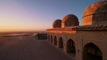 Golden sunset illuminating historic mosque in coastal desert