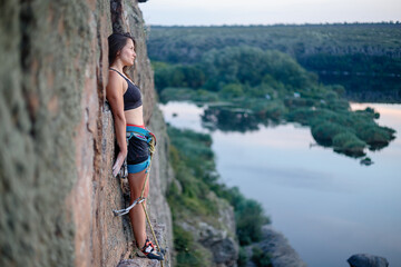 A girl climbs a rock. Woman engaged in extreme sport.