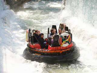 Wildwasserbahn im Freizeitpark mit lachenden Menschen