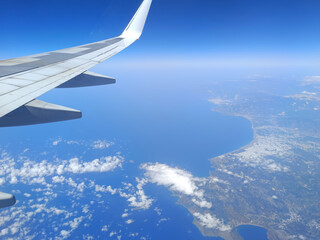 Obraz premium Aerial view from airplane window over the Mediterranean coast with wing in frame