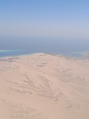 Endless desert mountain ridges seen from above in soft morning haze