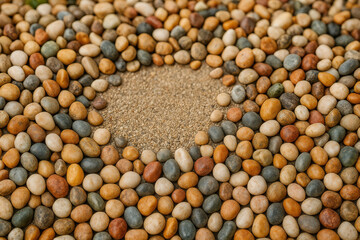 Harmony of Textures: A close-up captures a mosaic of smooth, colorful stones and a patch of fine sand. Each stone reflects the interplay of earth's natural elements