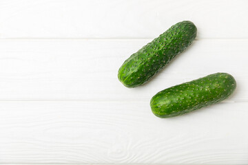 Cucumber on wooden background. Slice of cucumber on background. Fresh organic green cucumbers gherkin. Vegan. Salad ingredient. Farm vegetables. Cut vegetables with knife. Space for text. Copy space