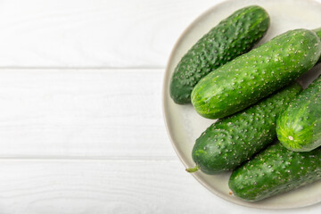Cucumber on wooden background. Slice of cucumber on background. Fresh organic green cucumbers gherkin. Vegan. Salad ingredient. Farm vegetables. Cut vegetables with knife. Space for text. Copy space