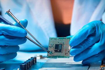 Close-up of hands working with microchip and tester on motherboard
