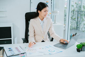 .Young Asian businessman doing document with calculator pen on laptop