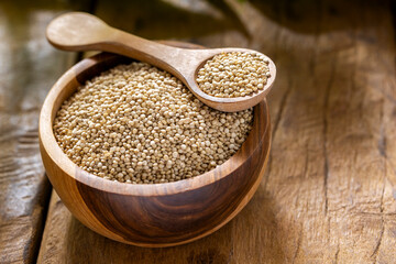 A pile of quinua grains is seen in the image, in a wooden container