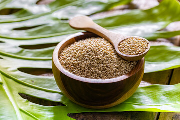 A pile of quinua grains is seen in the image, in a wooden container