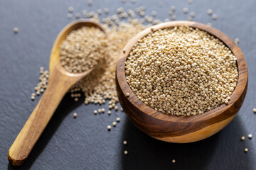 A pile of quinua grains is seen in the image, in a wooden container