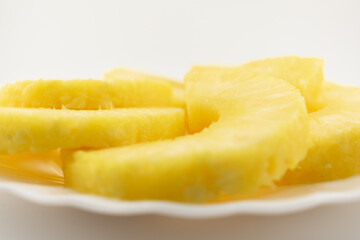 fresh pineapple rings neatly arranged on a white plate, evoking feelings of refreshing delight and healthy indulgence. Perfect for healthy snacks, fruit platters, or summer-themed culinary content