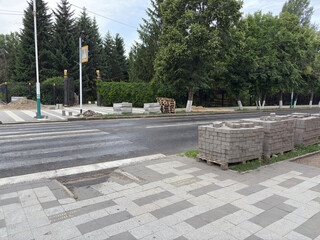 Street scene with pedestrian crossing and construction materials for replacing paving stones,