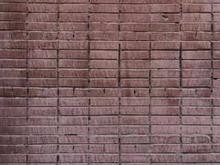 Close up of old red brick wall weathered by time and painted over