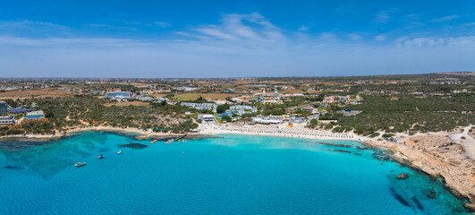 Aerial view of a crescent shaped beach in Ayia Napa, Cyprus, with turquoise waters, sun loungers,...