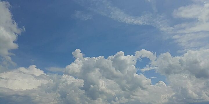 Natural blue sky with moving white clouds Cumulus, Cumulonimbus calvus and Cumulus congestus on sunny and stormy summer weather - timelapse. Topics: heaven, cloudscape, meteorology, sky background