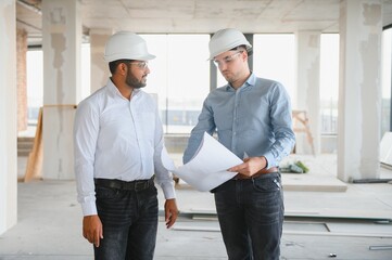 two architect engineers are walking in a constructed office building. implementation of the project