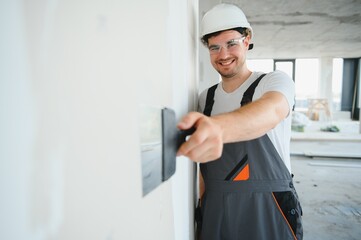 Indian construction site manager standing wearing helmet, thinking at construction site. Portrait...
