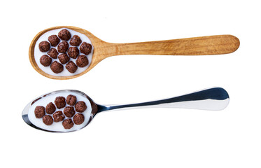 chocolate corn balls with milk in a metal spoon isolated on white background, top view.