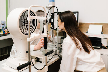 Ophthalmology procedure with slit lamp for eye and cornea checkup. Girl is visiting ophthalmologist...