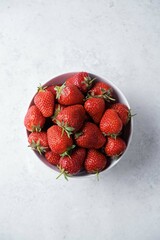 Fresh red strawberries in a white bowl