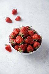 Fresh red strawberries in a white bowl