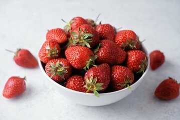 Fresh red strawberries in a white bowl