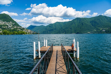 Boat pier on the Lake Lugano, Switzerland. European vacation, travel and nautical concept.