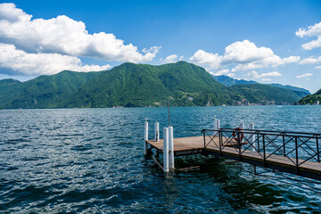 Boat pier on the Lake Lugano, Switzerland. European vacation, travel and nautical concept.