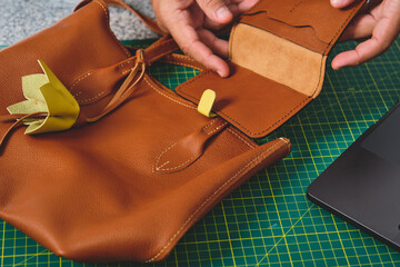 Artisan meticulously crafting leather bag and wallet, showcasing small business craftsmanship and...