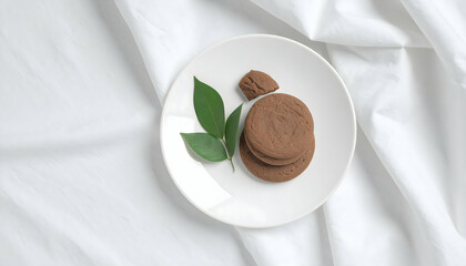 Brown Chocolate Cookies on White Plate with Green Leaves