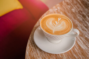 Cozy Coffee Cup with Latte Art on a Wooden Table in Bright Cafe Environment