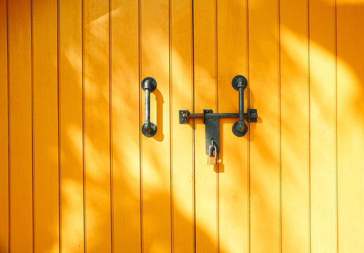 Yellow wooden door with metal lock and handles