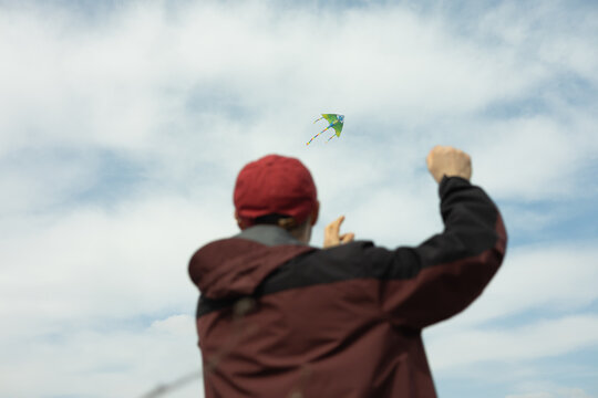 Dad flying a kite on a breezy day under blue skies