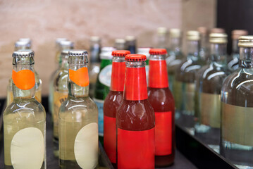 Close-up of glass drink bottles with red and clear labels on the shelf
