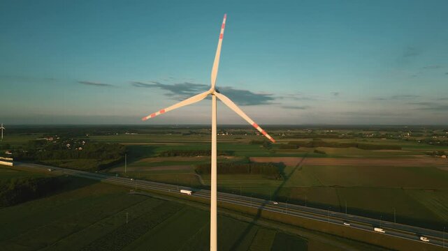 Aerial drone shot of a wind turbine at sunset, symbolizing clean and renewable energy in harmony with nature