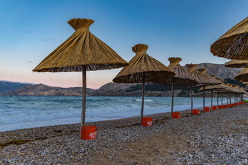Sunshades on the beach of Baska on the island of KRK, preparation for the tourist season in Croatia