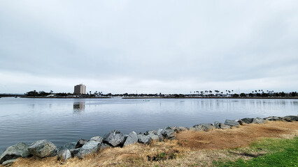 Marina and hotels in Quivira Basin as seen across mirror-like water surface of bay entrance channel from Mission Point Park, San Diego, California