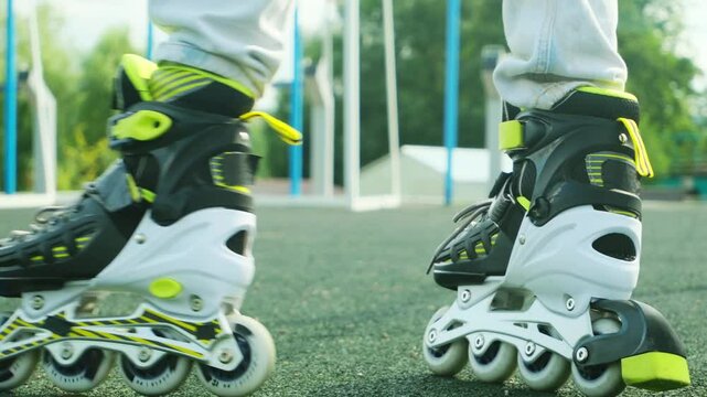 Close up roller blades. Roller skating girl kid in park rollerblading on inline skates.