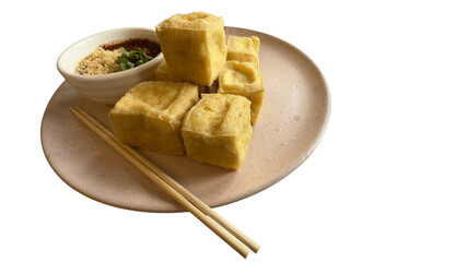 Isolated on a plate, golden fried tofu cubes are served with a sweet and spicy sauce sprinkled with crushed peanuts. This plant-based snack offers a rich source of protein.
