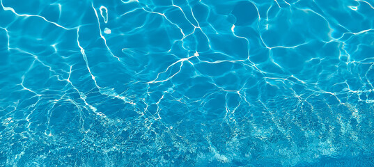 Background with glare on blue transparent water