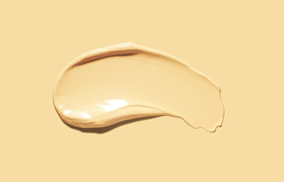 Make up smear foundation drops smudge texture beige yellow undertone isolated same colored background