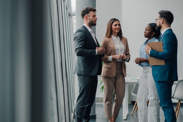 Business people talking during informal meeting in office hallway