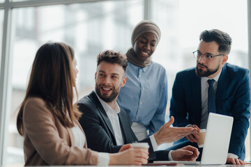 Business team discussing work in modern office with laptop